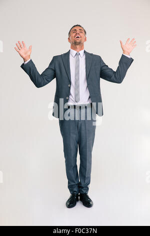 In voller Länge Portrait von einer fröhlichen Geschäftsmann Stnading isoliert auf weißem Hintergrund Stockfoto