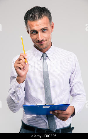 Glücklich Kaufmann mit Bleistift und Zwischenablage isoliert auf einem weißen Hintergrund. Blick in die Kamera Stockfoto