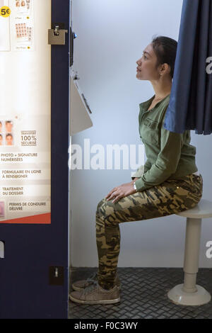 Frau macht das Porträt im Fotoautomaten Stockfoto