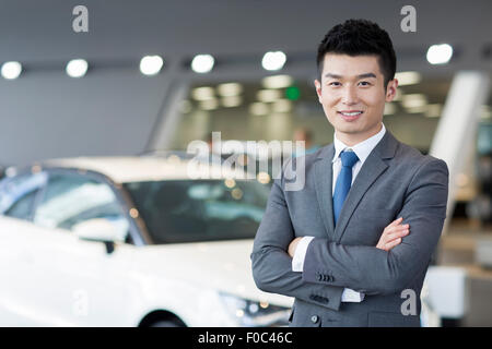 Zuversichtlich Verkäufer stehen mit neuen Autos im showroom Stockfoto