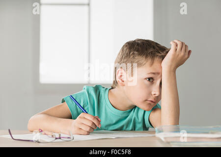Gelangweilte junge mit Hand auf die Stirn, die Hausaufgaben zu Hause Stockfoto