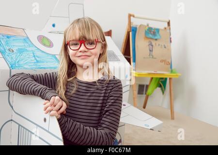 Porträt des jungen Mädchens neben Karton Raumschiff Stockfoto