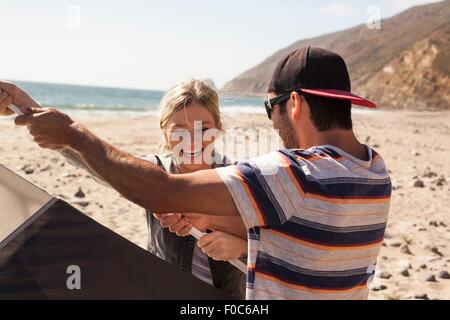 Paar einrichten Zelt am Strand von Malibu, Kalifornien, USA Stockfoto