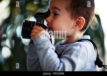 Jungen nehmen Foto mit Kamera Stockfoto