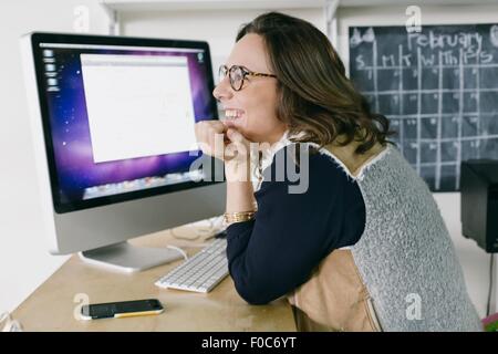 Porträt der jungen weiblichen Büroangestellten träumen am Schreibtisch Stockfoto