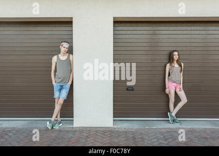 Junger Mann und Frau lehnte sich gegen geschlossene garage Stockfoto