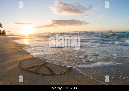 Friedenssymbol in Sand, Sonnenuntergang gezeichnet Stockfoto
