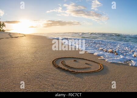 Smiley-Gesicht, gezeichnet in Sand, Sonnenuntergang, Hawaii Stockfoto