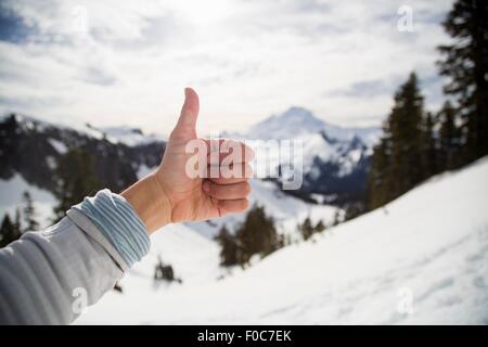 Weibliche Hand Daumen bilden vor Schnee bedeckt Ansicht, Mount Baker, Washington, USA Stockfoto