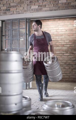 Brewer, tragen zwei Fässer Bier Stockfoto