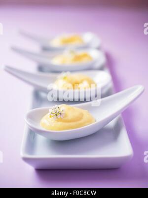 Vier Creme-Desserts auf China Löffel Stockfoto