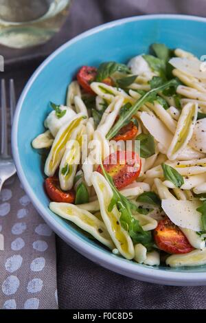 Nahaufnahme von Pasta-Salat mit Rucola und Tomaten Stockfoto