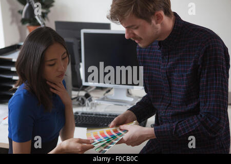 Junge männliche und weibliche Geschäftskollegen Farbfelder im Büro Farbe auswählen Stockfoto