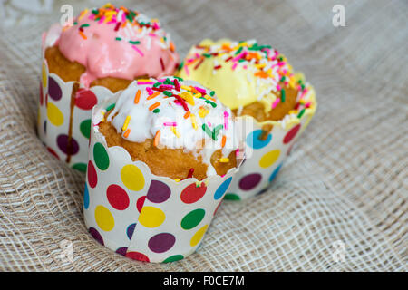 Mini-Muffins mit Zuckerguss, Sahne und Vanille Streuseln garniert Stockfoto