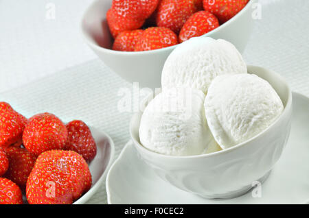 Nahaufnahme von einer weißen Schüssel mit Vanille-Eis und Erdbeeren, Makro, Detail, Horizontal, schräg Stockfoto