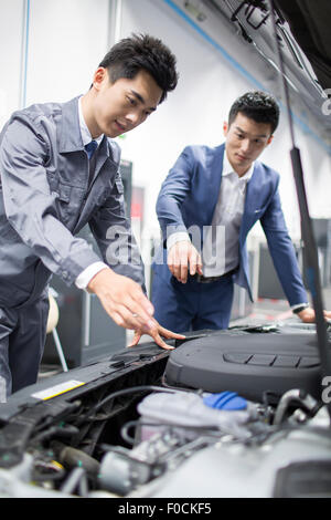 Kfz-Mechaniker im Gespräch mit Kfz-Halter Stockfoto