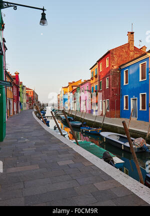 Sonnenaufgang an einem Kanal, gesäumt von traditionellen bunt bemalten Häusern Burano venezianischen Lagune Veneto Italien Europa Stockfoto