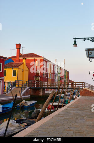 Mit dem Mond noch am Himmel beginnt die Sonne zu steigen auf die bunten Häuser der venezianischen Lagune Burano Veneto Italien Europa Stockfoto