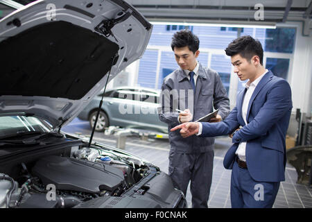 Kfz-Mechaniker im Gespräch mit Kfz-Halter Stockfoto