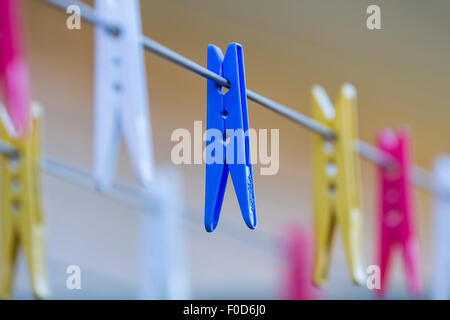 Bunte Wäscheklammern hängen auf einer Linie. Stockfoto