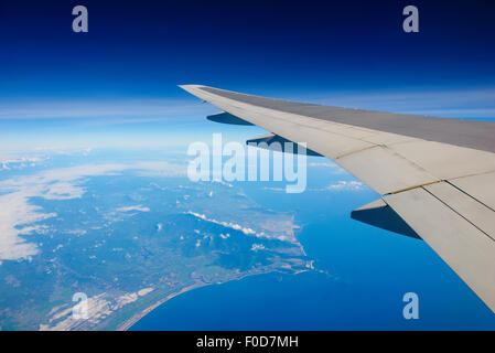 Flugzeug fliegen über Meer und Insel Stockfoto