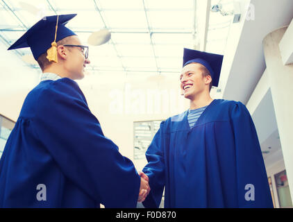 lächelnde Studenten in mortarboards Stockfoto