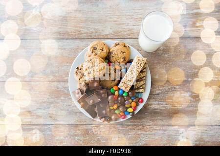 Nahaufnahme von süßen Speisen und Milchglas auf Tisch Stockfoto