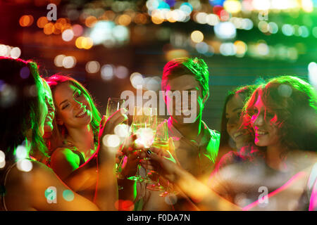 lächelnden Freunde mit Gläsern Champagner im club Stockfoto