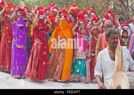Schlagzeuger führenden Frauen in der Regel buntes Kleid zu Beginn einer Prozession während des hinduistischen Festivals der Gangaur in Rajasthan Stockfoto