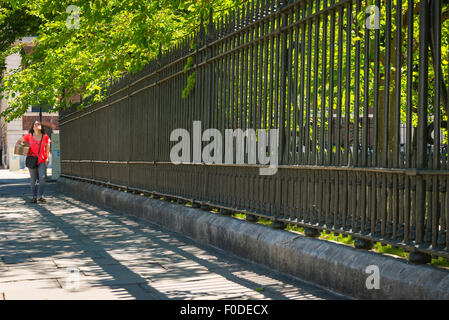 London Southbank Greenwich University Metall Eisen Stahl schwarz Geländer Dame female Mädchen Frau rote Brücke zu Fuß Stockfoto