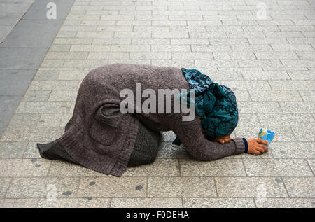 PARIS, Frankreich - 28. Juli 2015: Eine Obdachlose Frau für Geld auf den Champs-Elysees in Paris in Frankreich bettelt Stockfoto