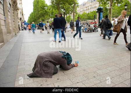 PARIS, Frankreich - 28. Juli 2015: Eine Obdachlose Frau für Geld auf den Champs-Elysees in Paris in Frankreich bettelt Stockfoto