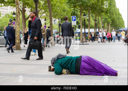 PARIS, Frankreich - 28. Juli 2015: Eine Obdachlose Frau für Geld auf den Champs-Elysees in Paris in Frankreich bettelt Stockfoto