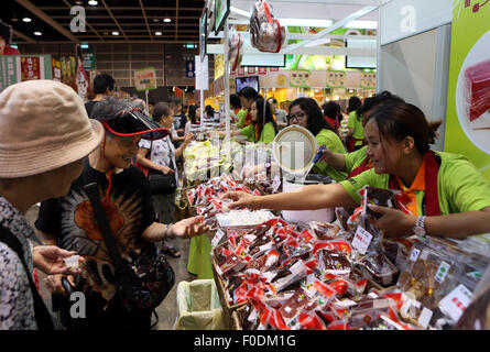 Hong Kong, China. 13. August 2015. Aussteller stellen ihre Lebensmittel Besucher in Hong Kong Food Expo 2015 in Hongkong, Südchina, 13. August 2015. Die fünf-Tage-Expo startete im Hong Kong Exhibition and Convention Center am Donnerstag, rund 1.200 Ausstellern aus 24 Ländern und Regionen. © Li Peng/Xinhua/Alamy Live-Nachrichten Stockfoto