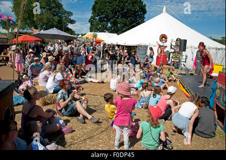 Familien beobachten einen akrobatischen Akt in der Sommersonne von Garküchen und Zelten am Hafen Eliot Festival Cornwall Stockfoto