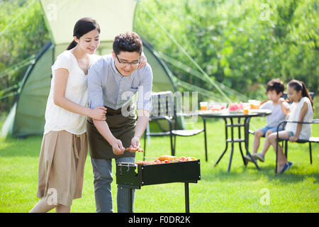 Junge Familie Grillen im freien Stockfoto