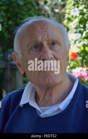 Ein älterer Mann mit Demenz sitzen ruhig auf der Suche verloren in seinen eigenen Gedanken. Stockfoto