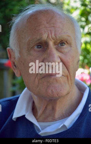 Ein älterer Mann mit Demenz sitzen ruhig auf der Suche verloren in seinen eigenen Gedanken. Stockfoto