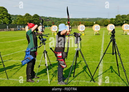 Zwei Frauen Bogenschützen in der Schlange, die verschiedene Arten von modernen Bogen schießen (compound und recurve) im Wettbewerb, West Yorkshire, Englan Stockfoto