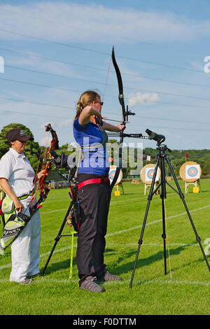 Zwei Frauen Bogenschützen in der Schlange, die verschiedene Arten von modernen Bogen schießen (compound und recurve) im Wettbewerb, West Yorkshire, Englan Stockfoto