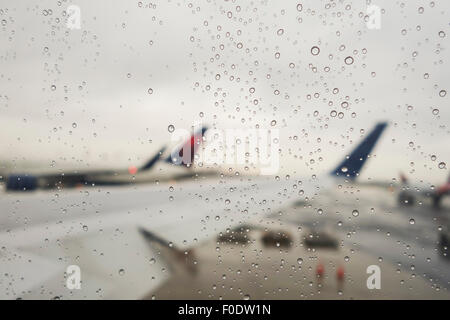 Regentropfen auf Flugzeug Fenster Newark Flughafen, Flügel aus dem Fokus, USA. USA. Stockfoto