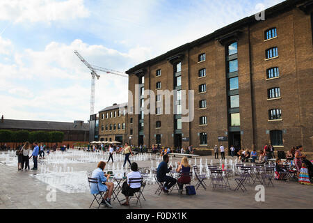 Leute sitzen rund um den Brunnen im Granary Square außerhalb Central Saint Martins Stockfoto