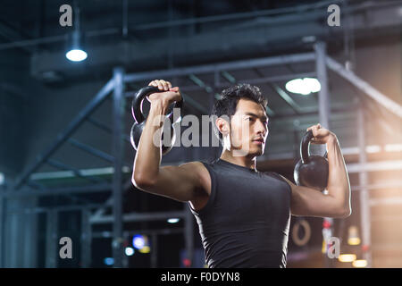 Junger Mann Training mit Kettlebells in Crossfit gym Stockfoto