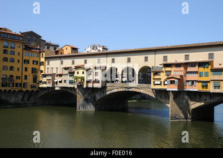 Die Ponte Vecchio oder die Alte Brücke, die älteste Brücke in Florenz überspannt den Fluss Arno. Erweiterungen zu den Geschäften ragen über den Fluss. Stockfoto