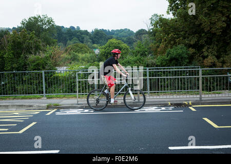 Stroud, Großbritannien. 11. August 2015. Großbritanniens kürzesten Fahrradweg ist gemalt auf eine neu geteerte Straße zwischen zwei Bushaltestellen der Schule. Die Gasse ist gegenüber einer lokalen Schule, wo Kinder und Jugendliche reitet ihren Bikes. Stroud. Gloucestershire. Vereinigtes Königreich. Bildnachweis: Alexander Caminada/Alamy Live-Nachrichten Stockfoto