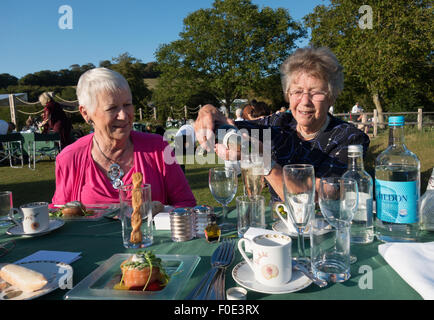 Zwei leitende ältere Frauen Spaß mit einem Champagner-Picknick, Glyndebourne, Sussex England UK Stockfoto