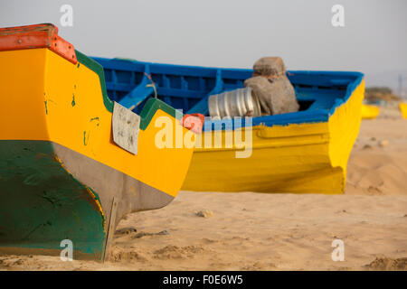 Zwei gelbe und blaue Fischerboote am Strand von Sidi Kaouki in der Nähe von Essaouira in Marokko stehen Stockfoto