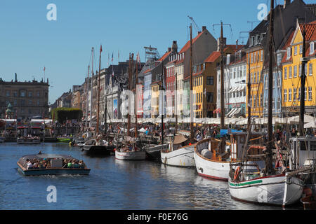 Nyhavn voll von alten Schiffen, überfüllten Kanal tour Boote und Leute an der Wasserseite und Pflaster Restaurants auf einer sehr hektischen Sommertag. Ambiente. Stockfoto