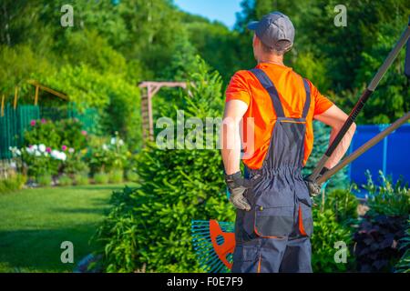 Bereit, Gärtner arbeiten. Kaukasische Gärtner mit Garten-Werkzeuge geht, beginnt seine Arbeit im schönen Garten. Stockfoto