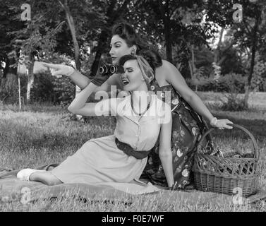 zwei Spion Mädchen verstecken Gesicht hinter dem Buch Pin-up- Stockfoto